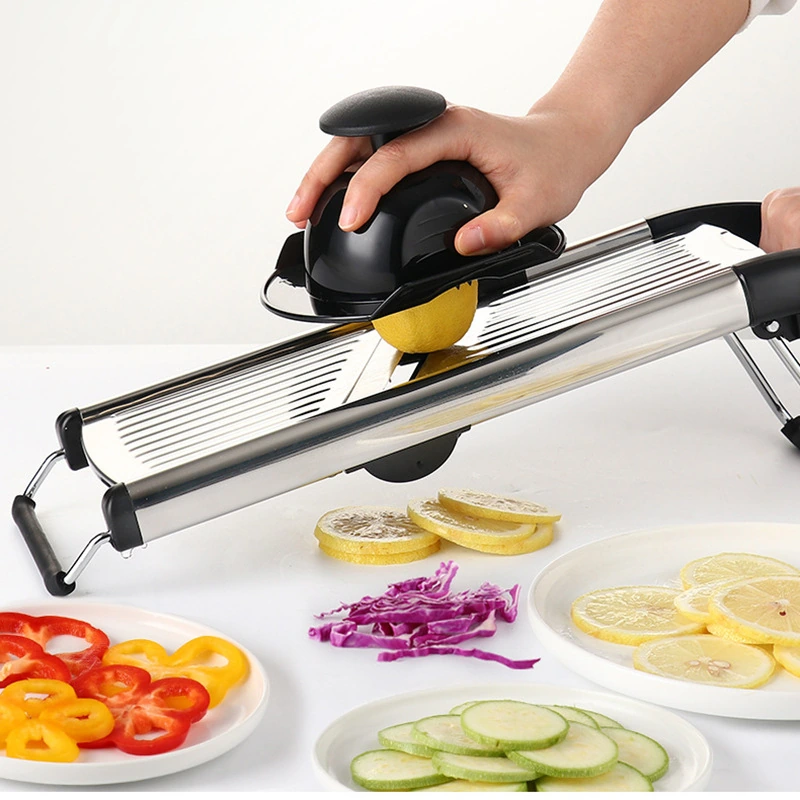 Manual mandoline vegetable slicer being used with a hand guard